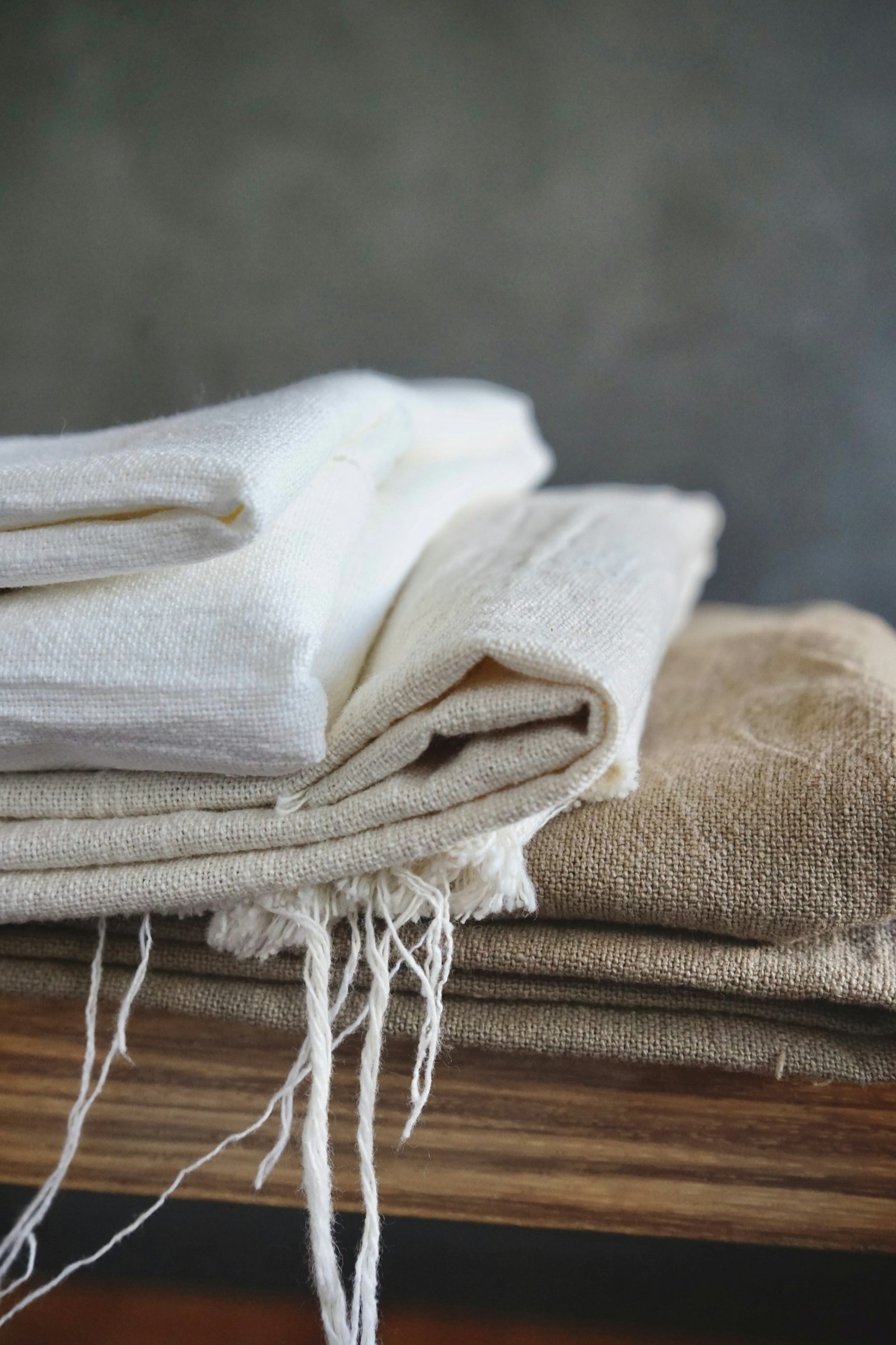 Folded handwoven cloths stacked on a wooden surface